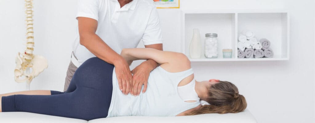 Chiropractor performing a spinal adjustment on a female patient in a clinic, focusing on reducing inflammation.