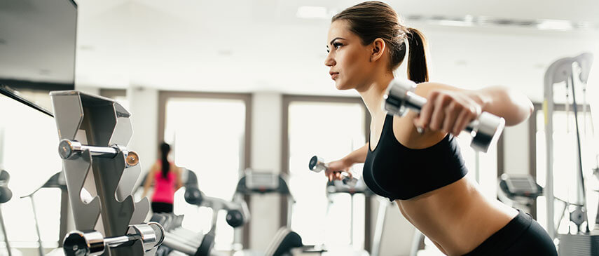 Woman exercising on a rowing machine at the gym for better results.