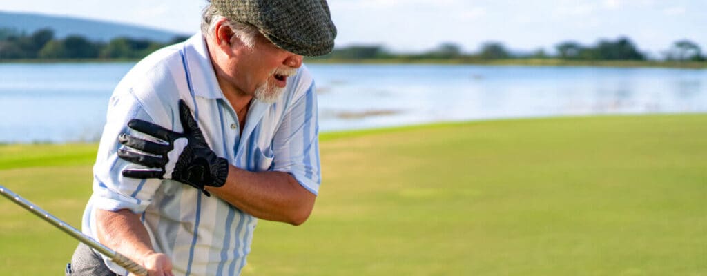 Senior golfer experiencing strain injuries and back pain on a golf course.