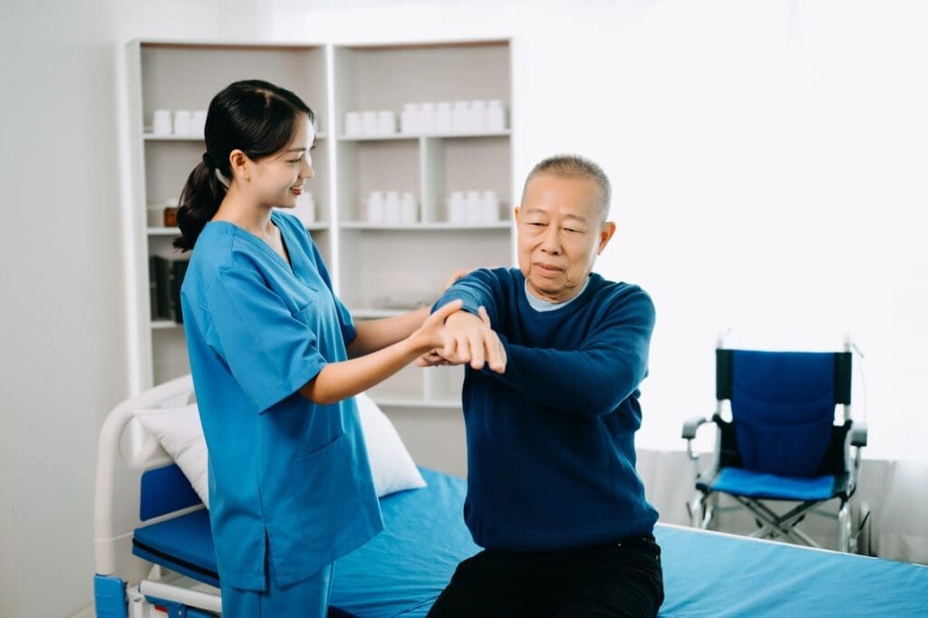 Healthcare professional assisting an elderly patient with exercise for pain management.