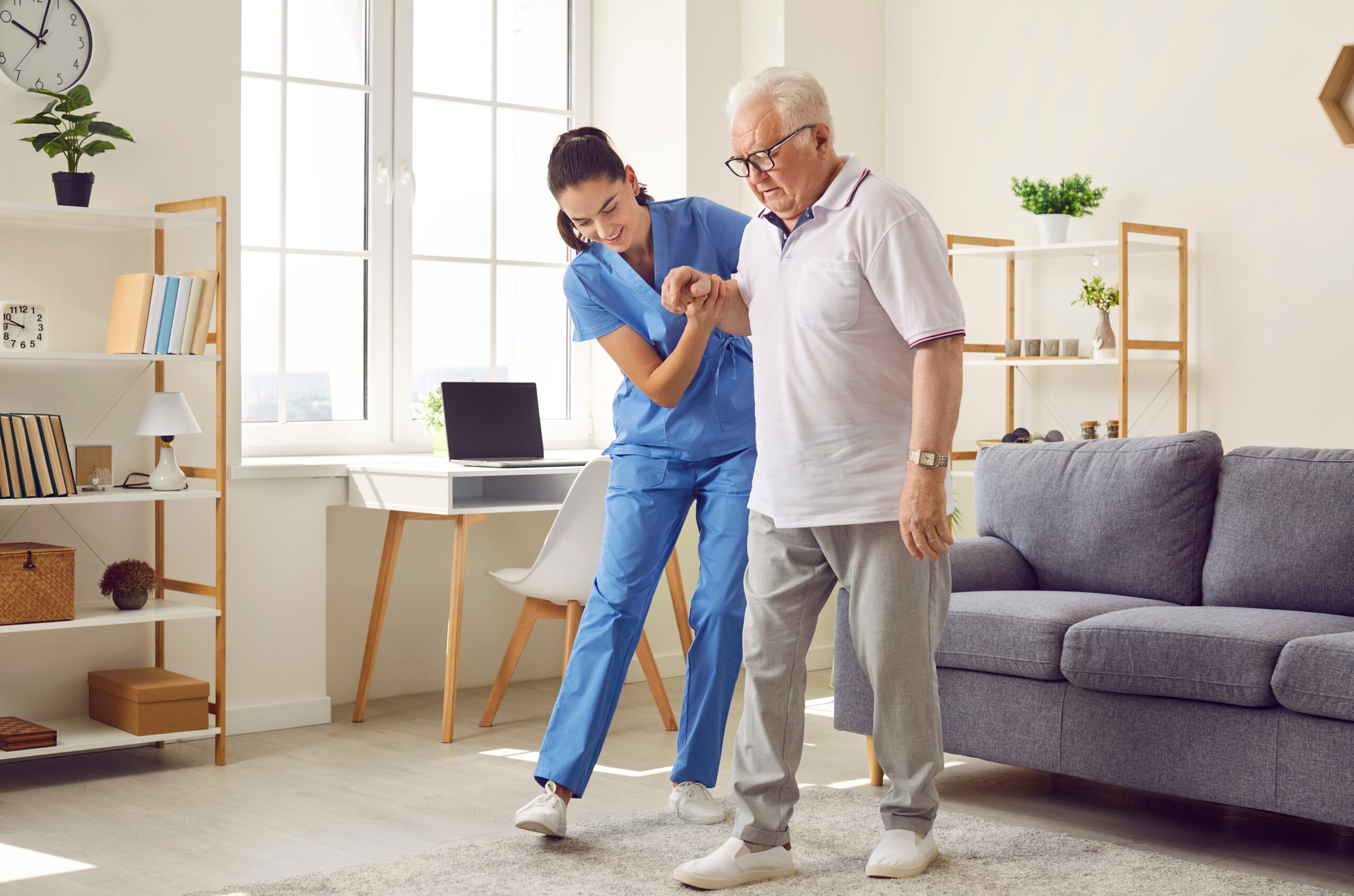 nurse helping a person after they had a stroke with their physical therapy