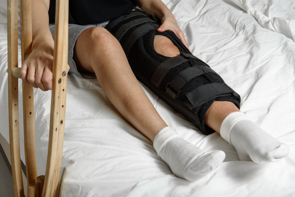 man in bed with crutches, Post-Surgery Recovery