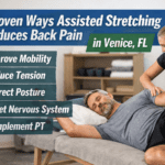 Clinician performing assisted stretching on a middle-aged man lying on a therapy table to help reduce back pain, with overlay text reading “5 Proven Ways Assisted Stretching Reduces Back Pain in Venice, FL” and benefits including improved mobility, reduced tension, posture correction, nervous system reset, and complementing physical therapy.